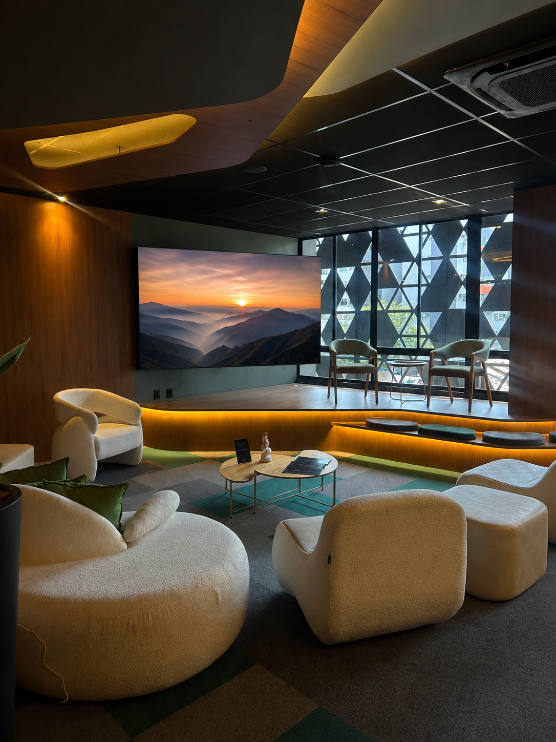 Palco com painel de LED e área de conversa em ambiente reservado