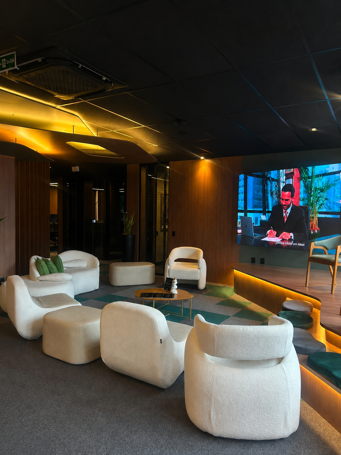 Lounge com poltronas claras e iluminação âmbar preparado para o encontro